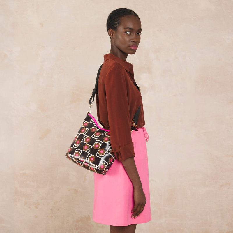 Model wearing the Cross Carry Crossbody Bag in Flower Pot Chestnut pattern by Orla Kiely