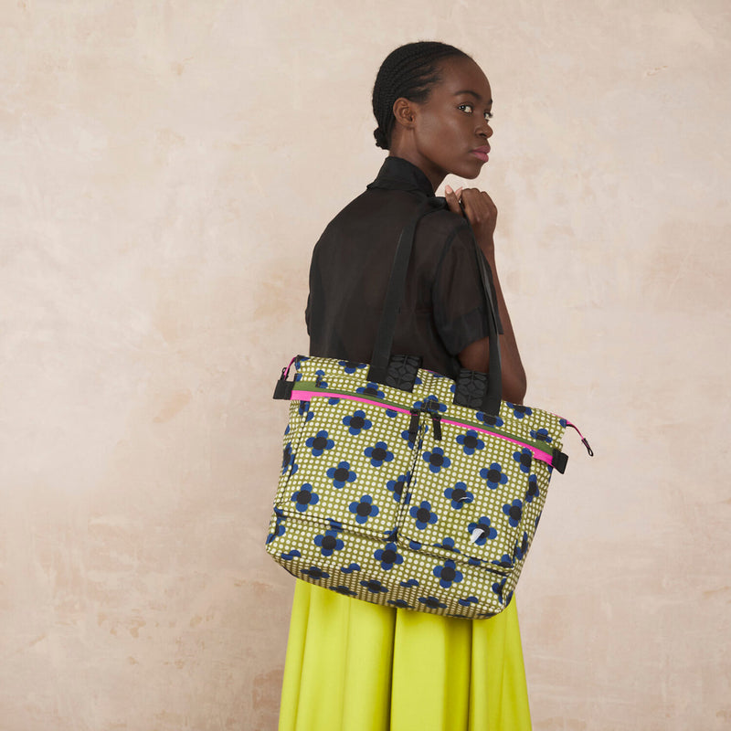 Model wearing the Axis Tote Bag in Flower Polka Dot Olive pattern by Orla Kiely