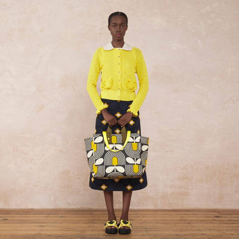 Model wearing the All In Tote Bag in Giant Striped Tulip Noir pattern by Orla Kiely