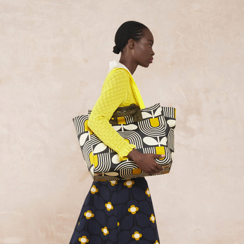 Model wearing the All In Tote Bag in Giant Striped Tulip Noir pattern by Orla Kiely