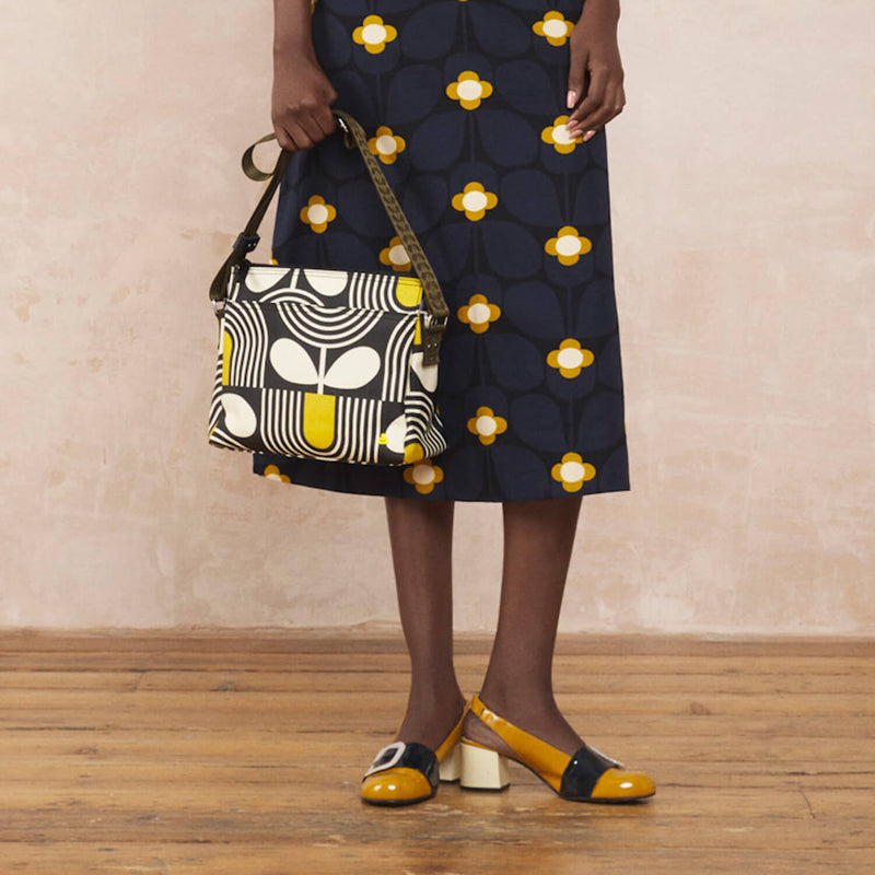 Model wearing the Fielder Crossbody in Giant Striped Tulip Noir pattern by Orla Kiely