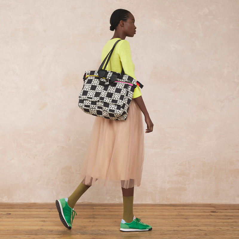 Model wearing the Axis Tote Bag in Lattice Flower Tile Onyx pattern by Orla Kiely