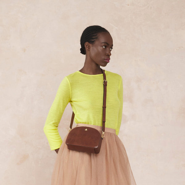 Model wearing the Babaluna Crossbody Handbag in Tan Punched Flower pattern by Orla Kiely