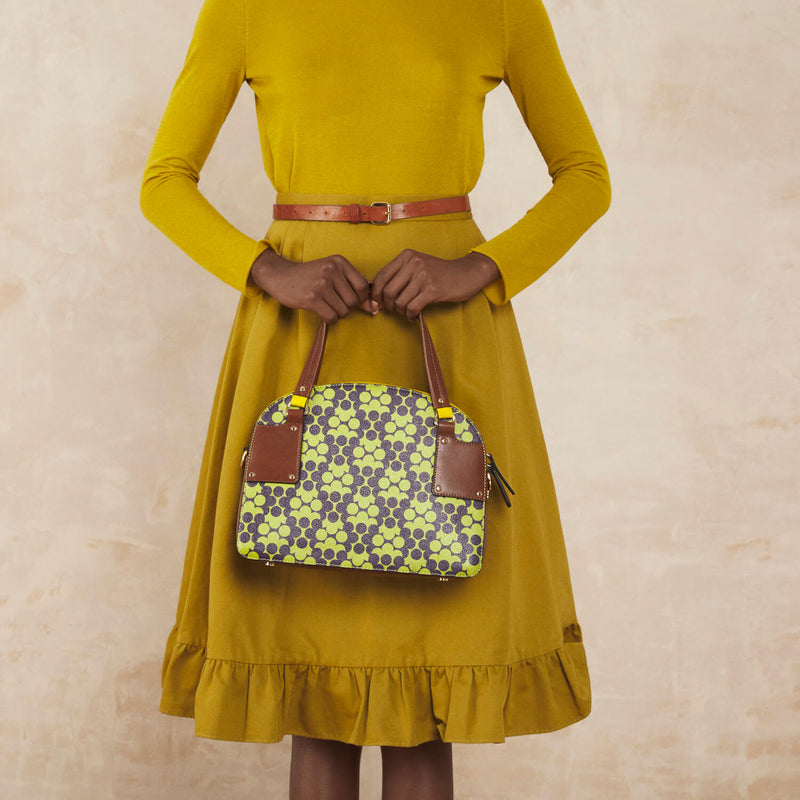 Model wearing the Luna Bowling Bag in Purple Puzzle Flower pattern by Orla Kiely