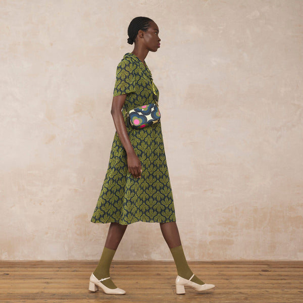 Model wearing the Duo Crossbody Bag in Radial Flower Rockpool pattern by Orla Kiely