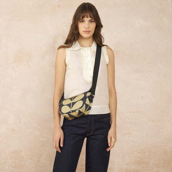 Model wearing the Rounder Crossbody in Solid Stem Oatmeal pattern by Orla Kiely