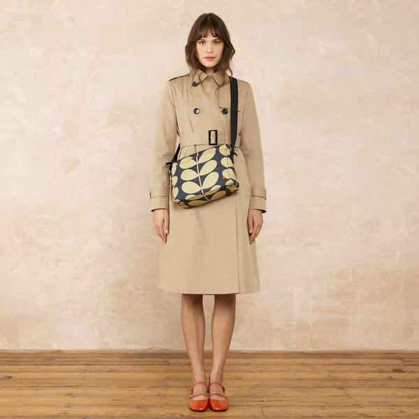 Model wearing the Fielder Crossbody in Solid Stem Oatmeal pattern by Orla Kiely