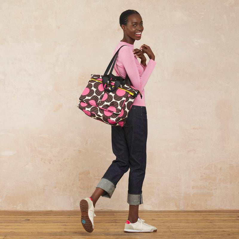 Model wearing the Axis Tote Bag in Striped Flower Azalea pattern by Orla Kiely