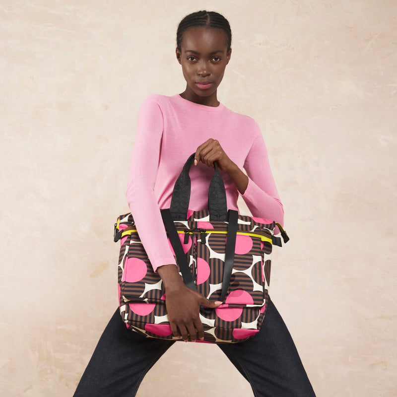 Model wearing the Axis Tote Bag in Striped Flower Azalea pattern by Orla Kiely